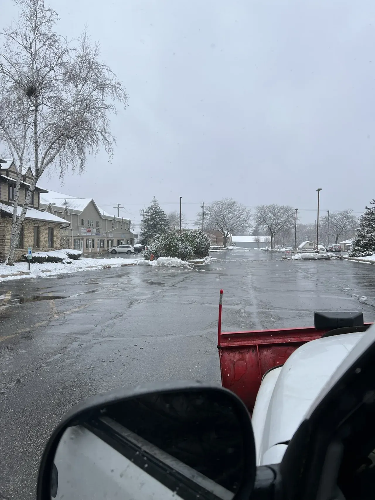 Arctic Fox truck with plow clearing a commercial retail lot in the Fox Valley